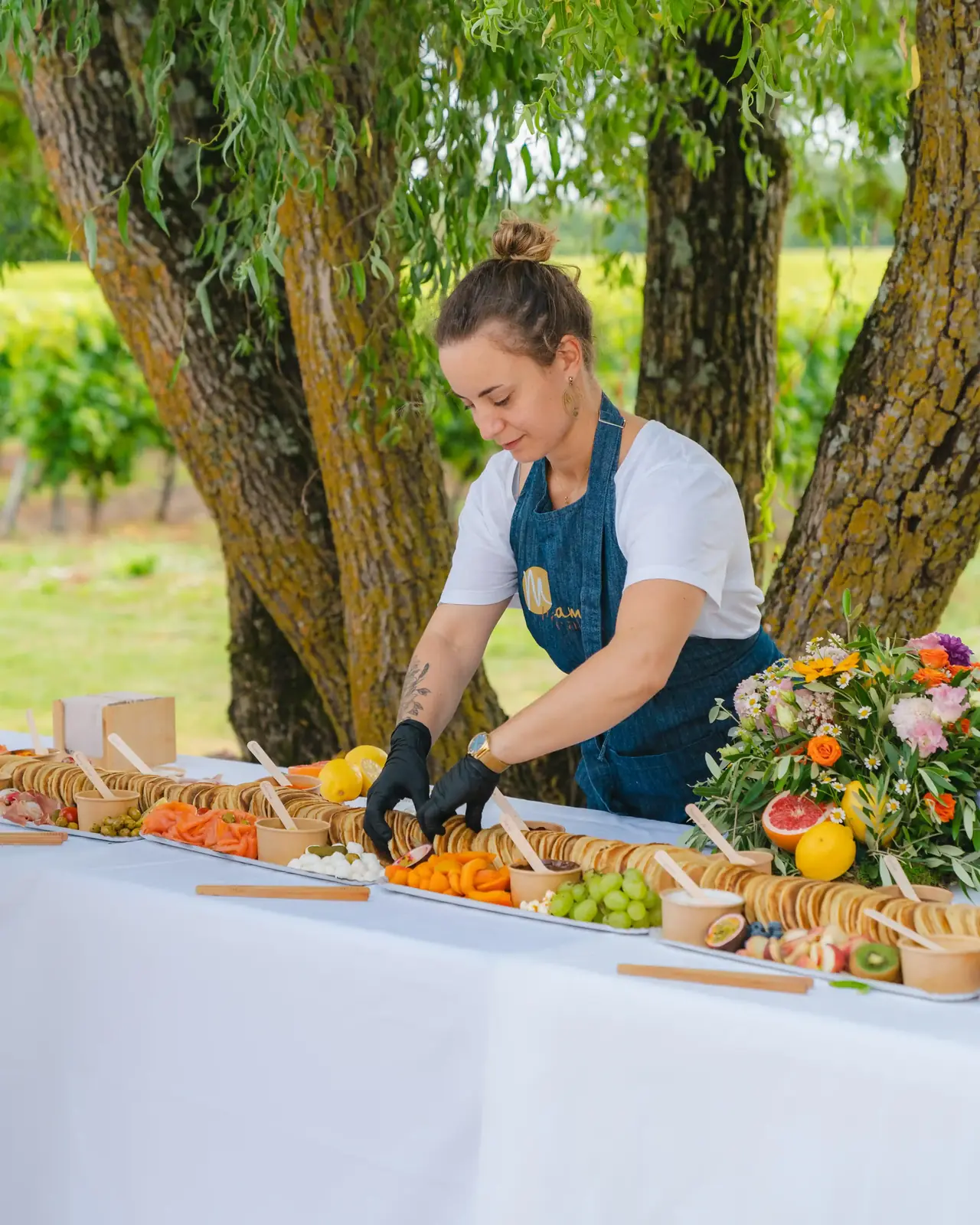 Laure dressant un buffet de pancakes en plein air