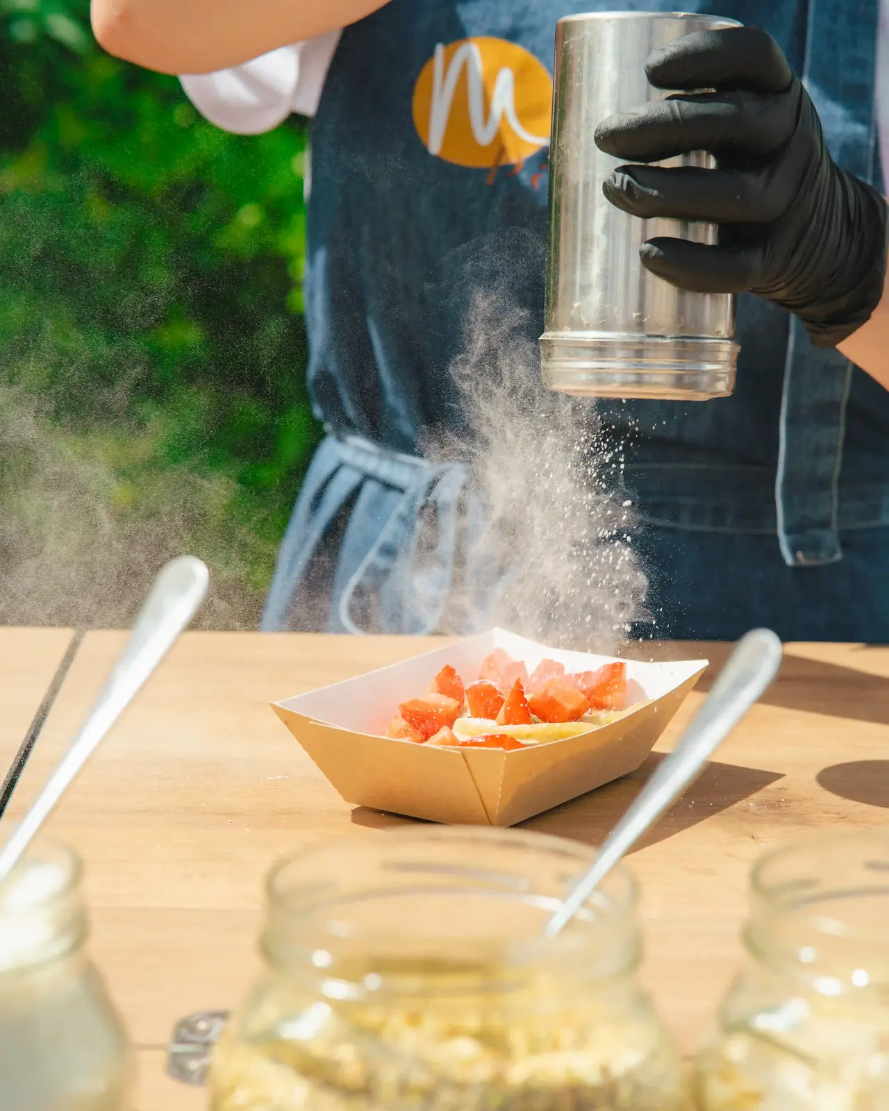 Saupoudrage de sucre glace sur des pancakes aux fraises