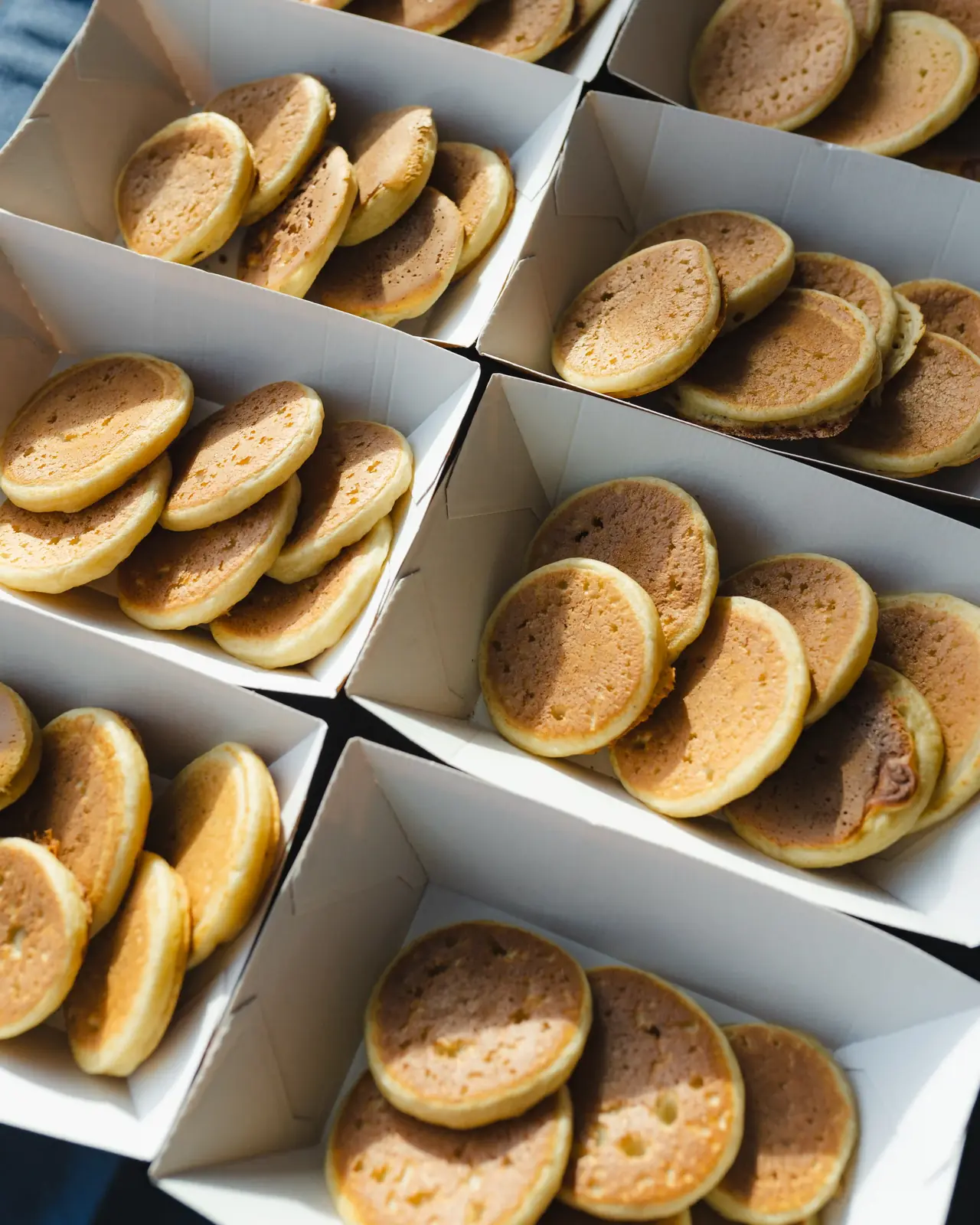 Boxes de mini-pancakes dorés préparées pour un événement