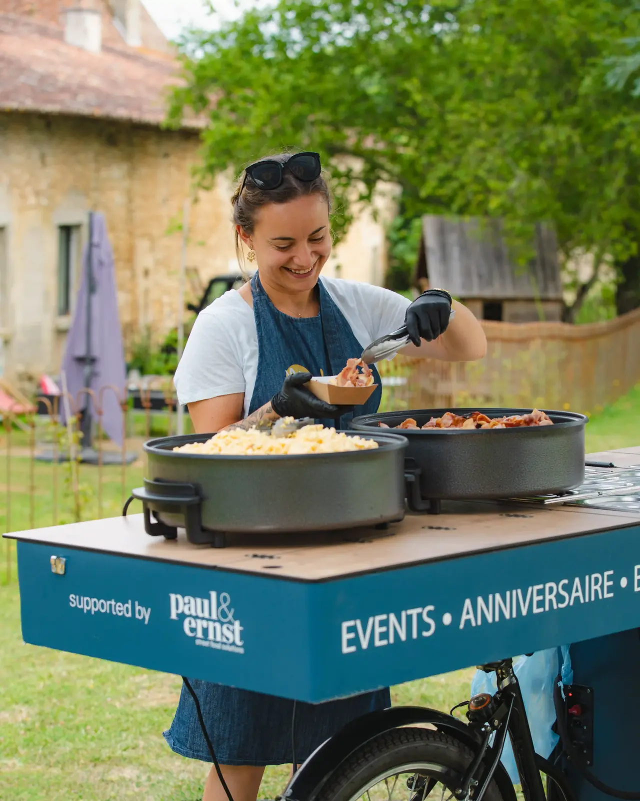 Laure cuisinant sur le triporteur Madame Pancakes en extérieur